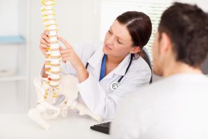 A chiropractor explaining facts to debunk common chiropractic myths for a patient.