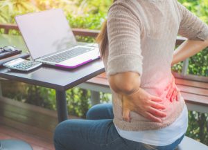 Chiropractor adjusting a desk worker's spine to relieve pain and improve posture.
