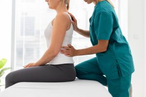 A chiropractor explaining the first chiropractic visit to a new patient during a consultation.