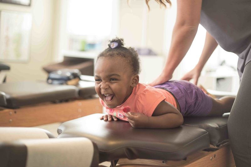 Chiropractor providing gentle pediatric chiropractic care to a young patient.