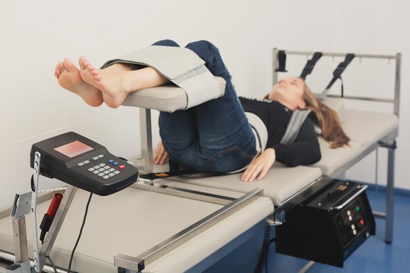 Patient using inversion table for gentle spinal stretching