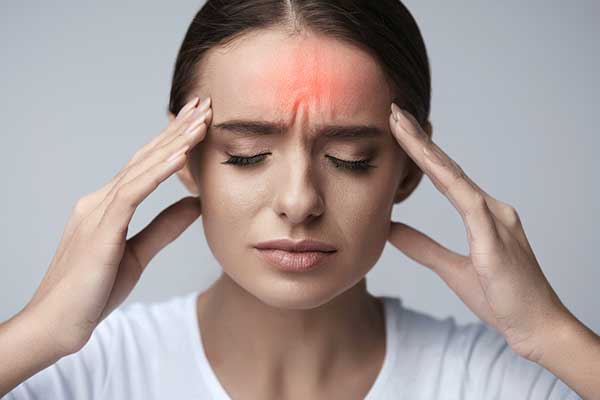 Person holding head due to migraine pain