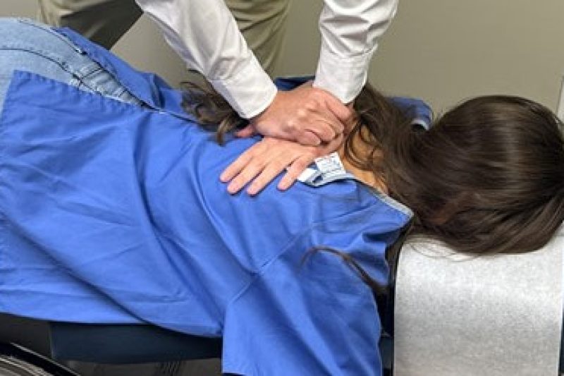 Chiropractor performing mid back adjustment technique