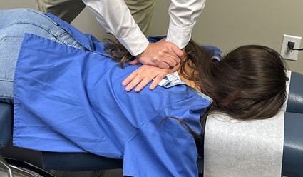 Chiropractor performing mid back adjustment technique