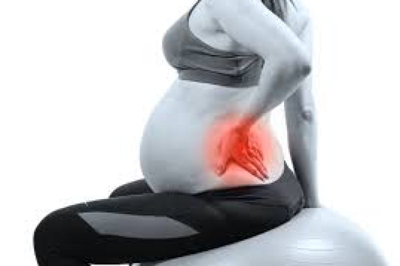 Pregnant woman holding lower back in discomfort