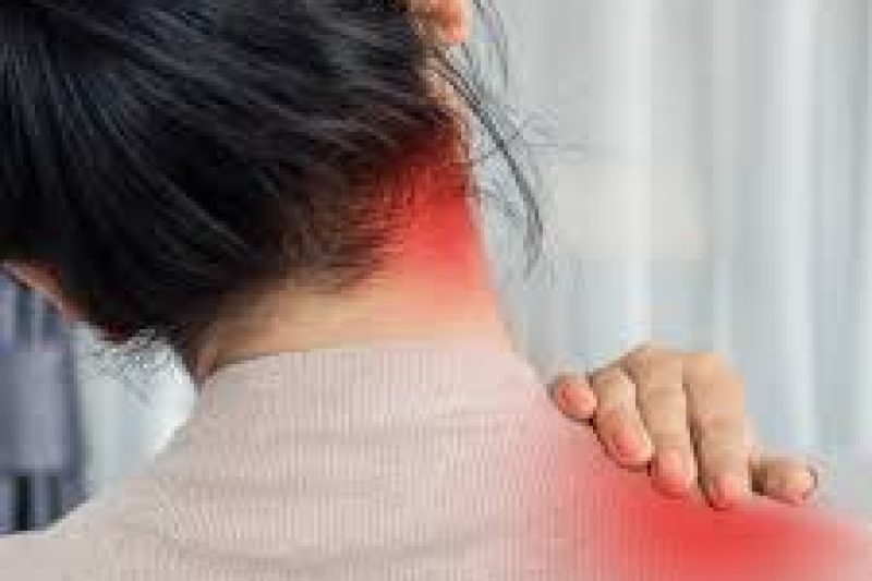 Person holding neck and shoulder in pain while sitting