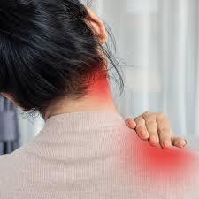 Person holding neck and shoulder in pain while sitting