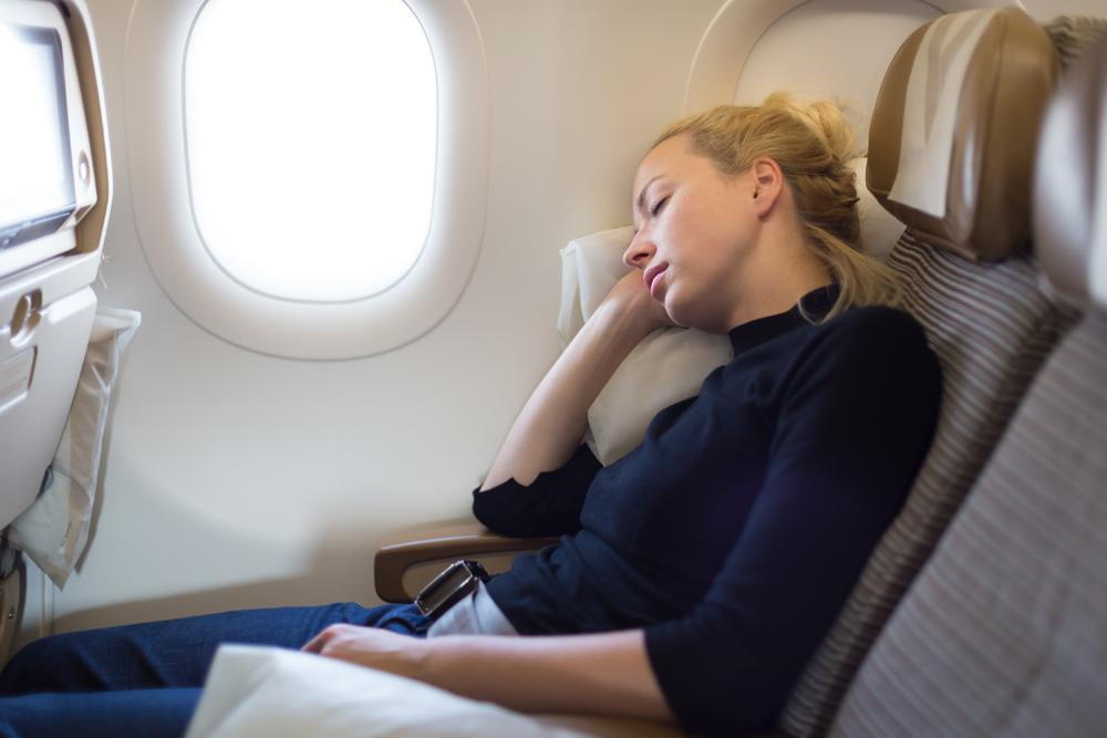 San Diego traveler experiencing neck pain from forward head posture on airplane